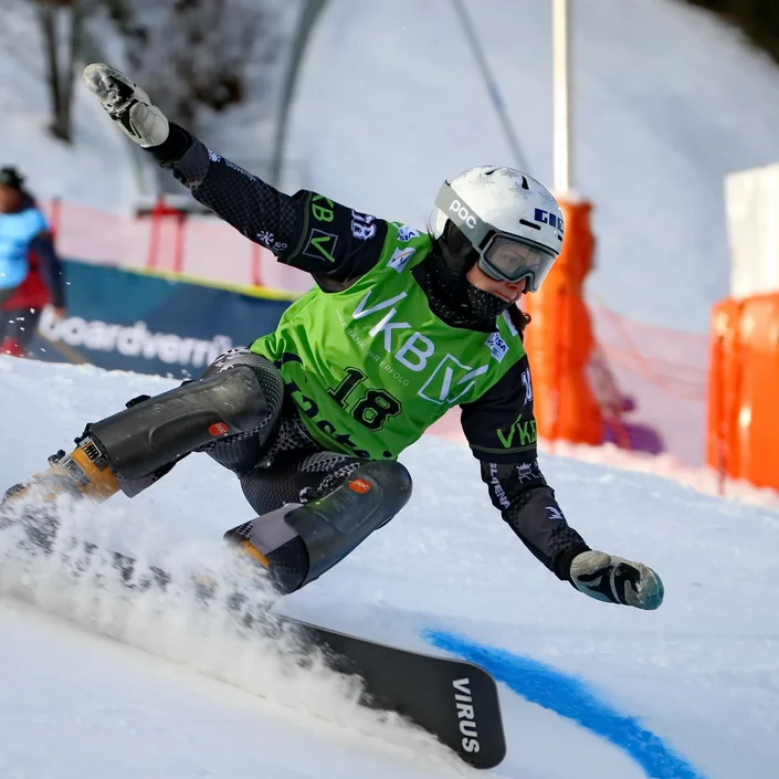 Eine Snowboardfahrerin trägt das Trikot mit VKB-Branding