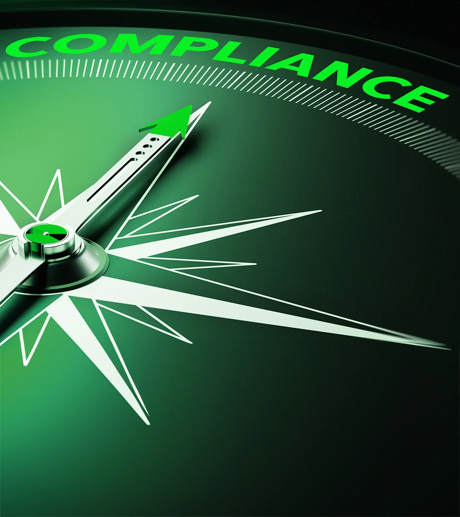 Close-up-Foto: Grüner Kompass, die Nadel zeigt auf die Beschriftung "Compliance"