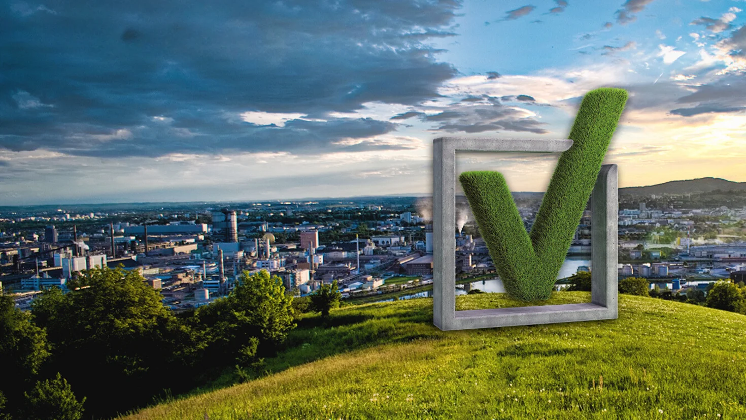 Statue der VKB-Bildmarke auf einer Wiese mit Blick auf Linz