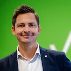 Christian Burger vor einem grünen VKB-gebrandeten Hintergrund